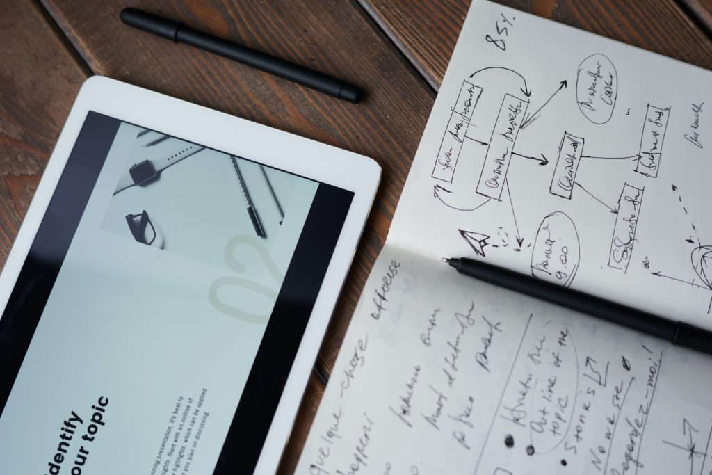 An architects' tablet with a notebook on a wooden table.