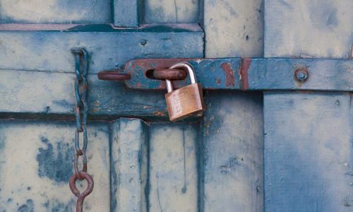 About Us: A blue door with a padlock on it signifies the secure entryway to our organization.